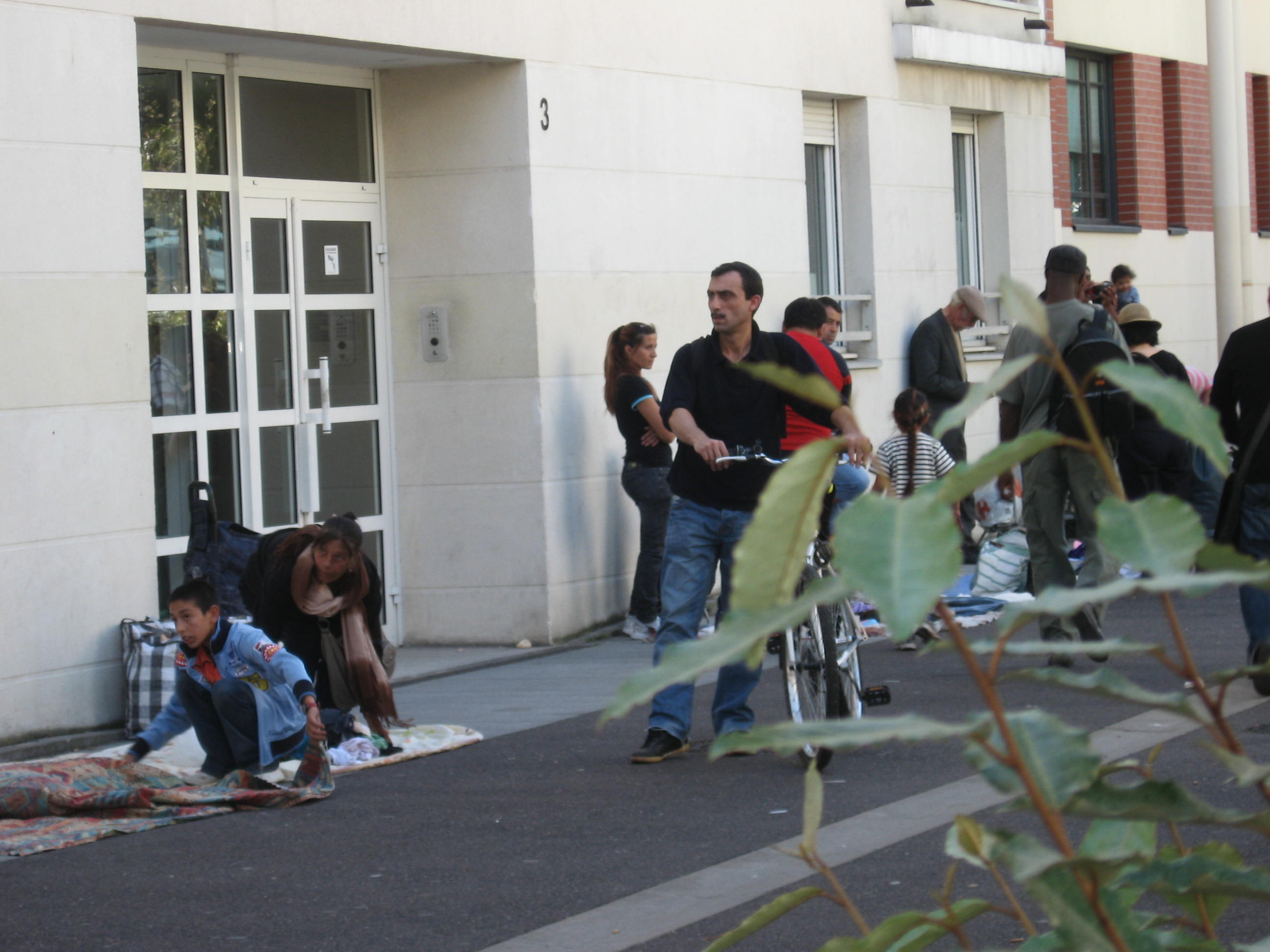 vendeurs à la sauvette devant une porte d'entrée d'immeuble